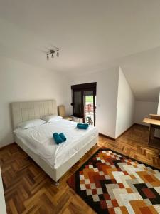 a bedroom with a large white bed and a rug at Prestige Old Town Villa in Sarajevo