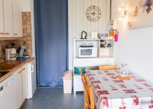 a small kitchen with a table and a microwave at Studio avec vue sur la montagne à Villard de Lans - 34 m² in Villard-de-Lans