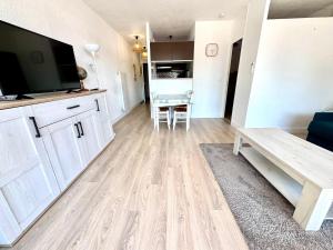 a living room with a couch and a television and a table at Reflet d’Azur - 4 personnes - Point zéro in La Grande Motte
