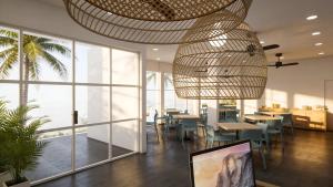 a restaurant with tables and chairs and a chandelier at Nala Inn in Fulidhoo +4 photos
