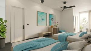 a bedroom with three beds and a ceiling fan at Nala Inn in Fulidhoo