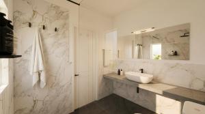 a white bathroom with a sink and a mirror at Nala Inn in Fulidhoo