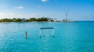 a person on a paddle board in a body of water at Nala Inn in Fulidhoo