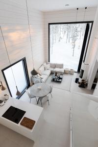 a living room with white furniture and a large window at Polaris Villas - Villa Deluxe in Muonio