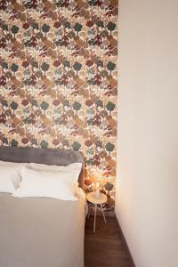 a bed in a room with a floral wall at B&B Università in Catania +81 photos