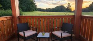 two chairs and a table on a porch with a view at Gasthaus Zum Schneider in Pottenstein