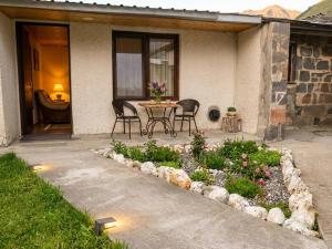 a patio with a table and chairs and flowers at Relax in the mountains - kazbegi in Arsha