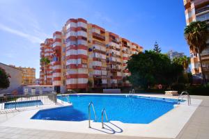 a swimming pool in front of a apartment building at Brisa de Torre in Torre del Mar +4 photos