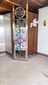 a room with a glass cabinet with a fan at Maison cosy avec piscine partagée à Capesterre-Belle-Eau in Besnard +25 photos