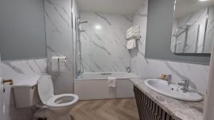 a white bathroom with a toilet and a sink at Canavans Hotel in Garvaghy