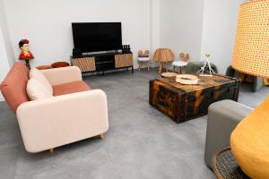a living room with two chairs and a tv at Caribean Style in Middelkerke