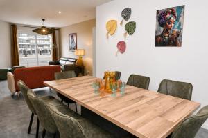 a dining room with a wooden table and chairs at Caribean Style in Middelkerke
