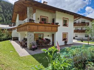 a house with a balcony and a patio at Alpinchalet Ortler in Solda