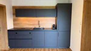 a kitchen with blue cabinets and a sink at Ferienwohnung Lisa in Grabenstätt