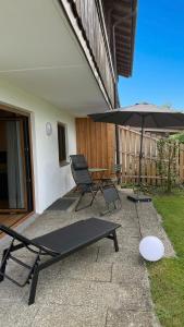 a patio with a table and an umbrella at Ferienwohnung Lisa in Grabenstätt