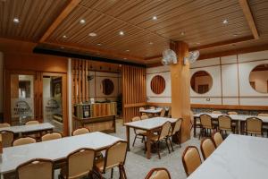 a restaurant with tables and chairs in a room at Hotel Asopalav in Junagadh