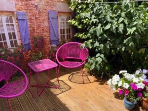 three pink chairs sitting on a deck with flowers at Double Bedroom with Private Entrance in Weymouth