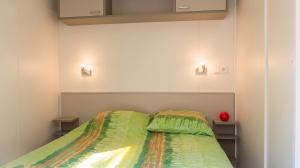 a bedroom with a bed with a green comforter at Chalet charmant à Saint-Jean-du-Gard in Saint-Jean-du-Gard