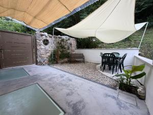a patio with an umbrella and a table and chairs at L'Intermezzo in Venzone