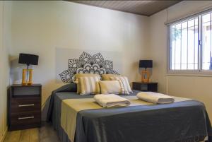 a bedroom with a bed with two night stands and a window at Monte Aromas Casas en la Naturaleza Roldán in Roldán +43 photos