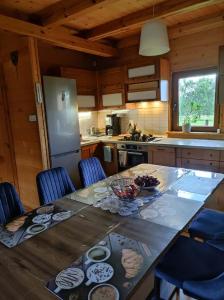 a kitchen with a large wooden table with blue chairs at Zielona Dolinka in Kostrzyca