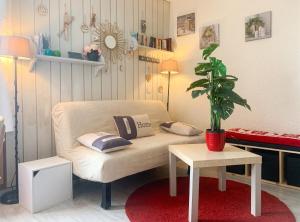 a living room with a couch and a potted plant at Studio chaleureux à Uvernet-Fours, 25m² avec vue montagne in Uvernet