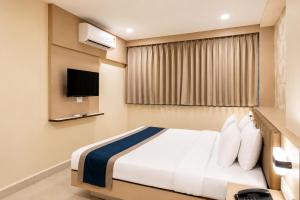 a hotel room with a bed and a tv at Hotel Eagle Empire in Madgaon