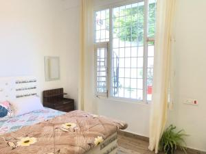 a bedroom with a bed and a large window at JIJIVISHA Homestay in Bhīm Tāl