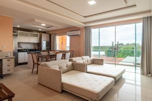 a large living room with a couch and a kitchen at Pousada D' Areia in Barreirinhas