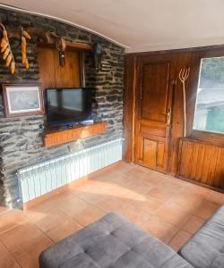 a living room with a tv on a stone wall at Spacious House in Canejan with Mountain View in Caneján