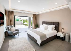a bedroom with a large bed and a chair at Grey Stones Villa by HolidayKeys in Kyrenia +12 photos
