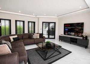 a living room with a couch and a tv at Grey Stones Villa by HolidayKeys in Kyrenia