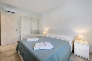 a bedroom with a blue bed with towels on it at Al Casel - Appartamento Collina in Torri del Benaco