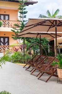 a group of benches with an umbrella at Pousada D' Areia in Barreirinhas