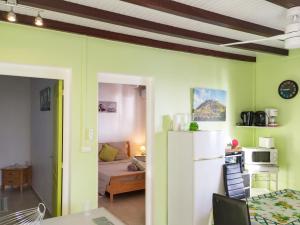 a kitchen and living room with a table and a refrigerator at Appartement confortable avec vue sur mer à Bouillante, 50 m² in Bouillante