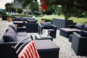 un groupe de chaises et de tables battant pavillon américain dans l'établissement Hotel Du Moulin, à Ligneuville