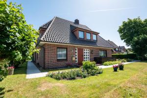 a brick house with a garden in the yard at Kim im Haus Wega in Westerland