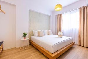 a bedroom with a large white bed with a window at Dhermi's Icon Big 1BR Apt 9 in Dhërmi