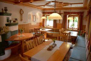 a dining room with wooden tables and chairs at Ferienhof Pfaffenlehen in Maria Neustift