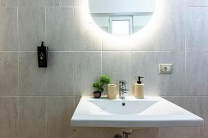 a bathroom with a white sink and a mirror at Dhermi's Icon Big 1BR Apt 9 in Dhërmi +3 photos
