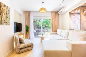 a living room with a white couch and a tv at Dhermi's Icon Big 1BR Apt 9 in Dhërmi