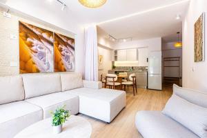 a living room with a white couch and a kitchen at Dhermi's Icon Big 1BR Apt 9 in Dhërmi