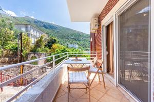 a balcony with two chairs and a table on it at Dhermi's Icon Big 1BR Apt 9 in Dhërmi