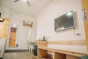a kitchen with a table and a tv on the wall at 3BU Hostel Baguio - Bonifacio in Baguio +16 photos