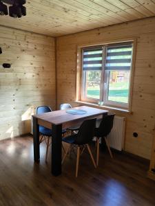 a dining room with a table and chairs in a cabin at Domek MAGELLAN Cisna 11 in Cisna