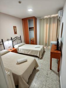 a hotel room with two beds and a television at H Arkanta in Arganda del Rey