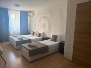 a hotel room with two beds and a couch at Къща за гости Стил in Kiten