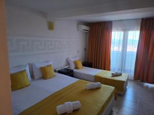 a hotel room with two beds and a window at Къща за гости Стил in Kiten