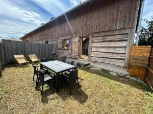 a table and chairs in front of a barn at Golden Nest in Courteranges