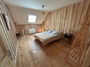 a bedroom with a bed and a wooden floor at Golden Nest in Courteranges